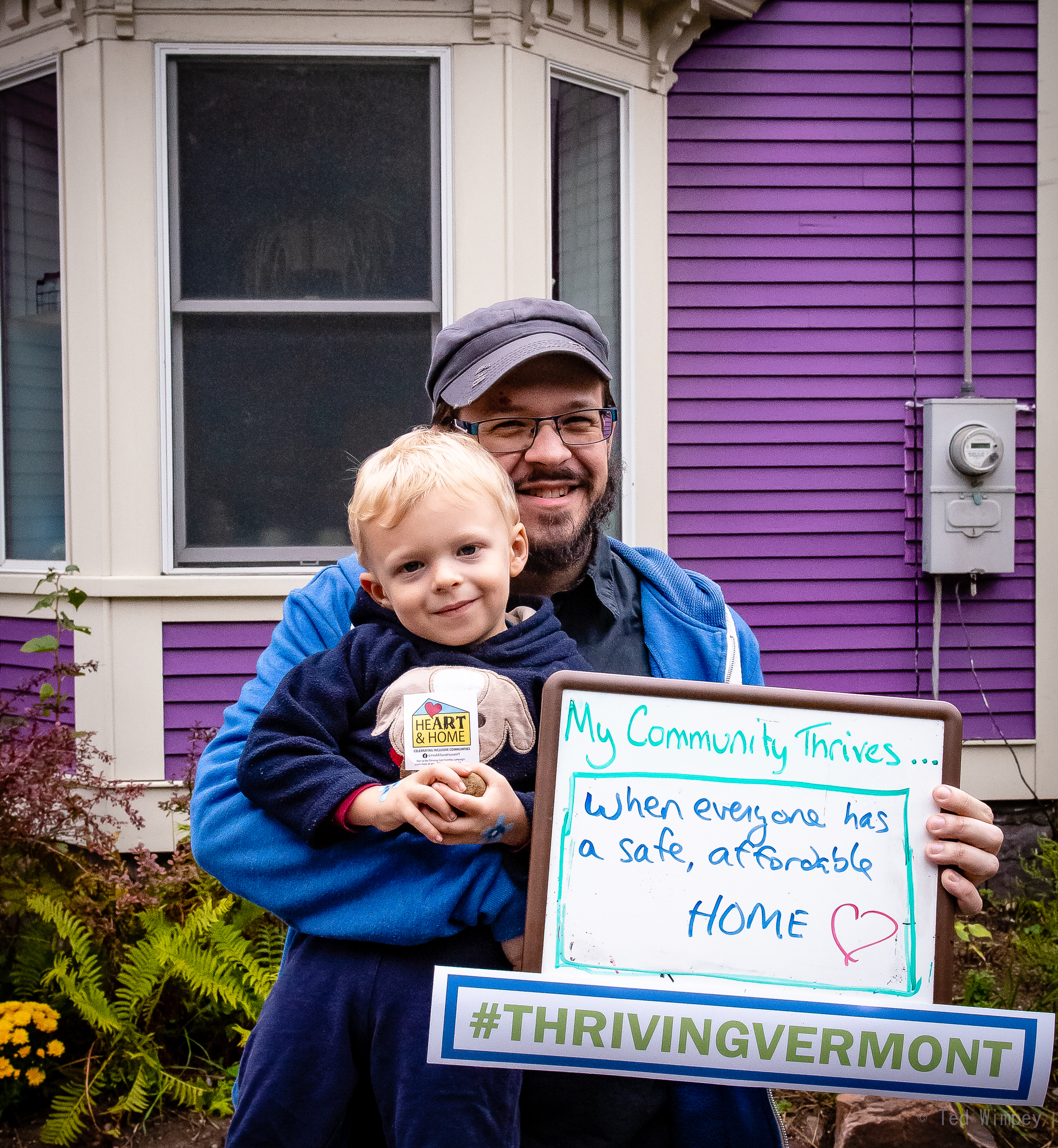 Person holding child and sign that says 